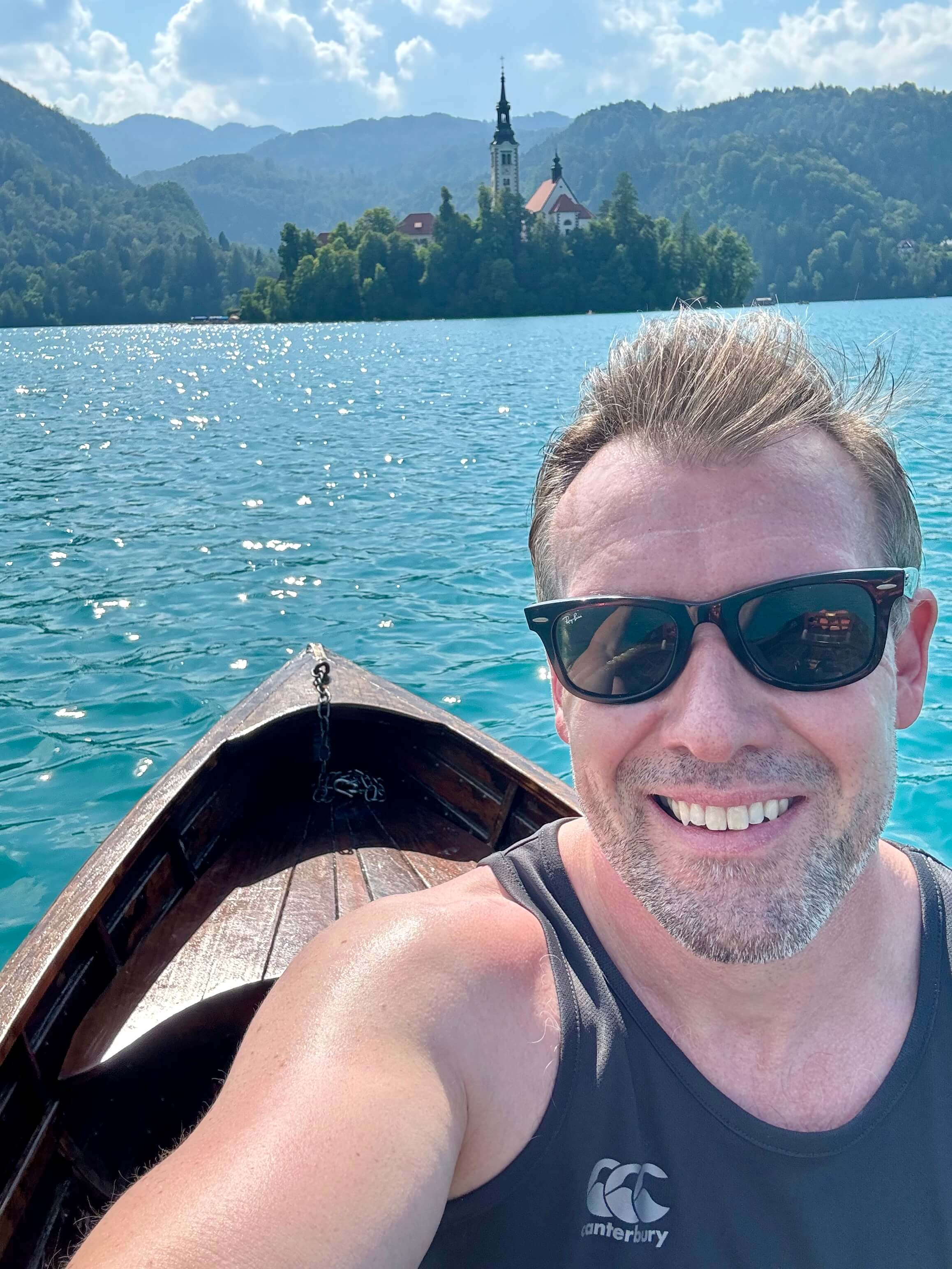 Picturesque Slovenian landscape featuring emerald green lakes, dense forests, and dramatic limestone peaks characteristic of the Julian Alps region