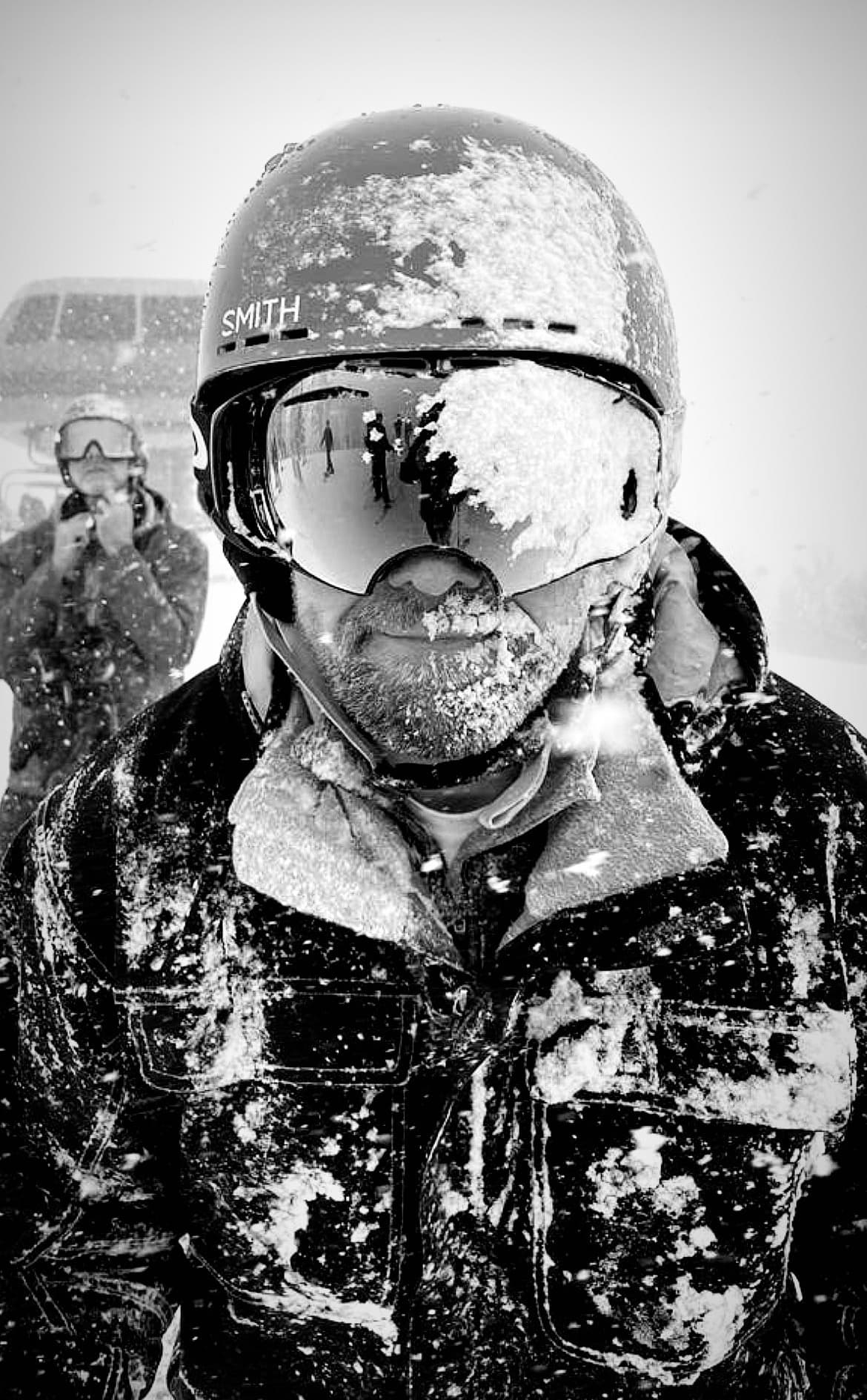 Portrait in snowy mountain conditions with frost-covered beard and winter gear, showcasing the exhilarating experience of cold weather outdoor activities